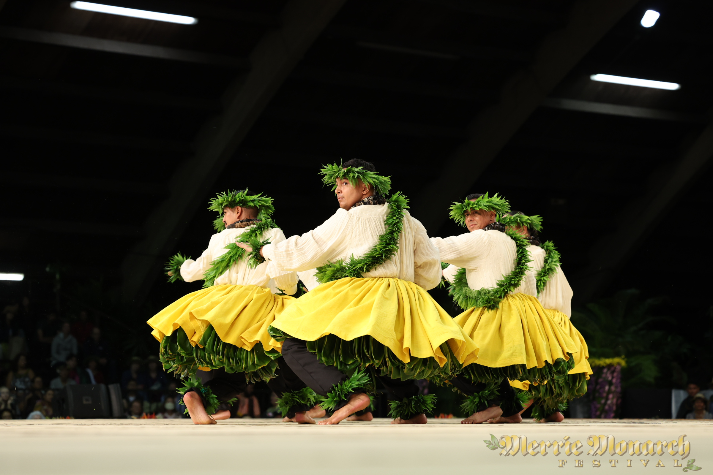 Kane hula dancers wearing yellow and shell lei with ankle kupe'e.
