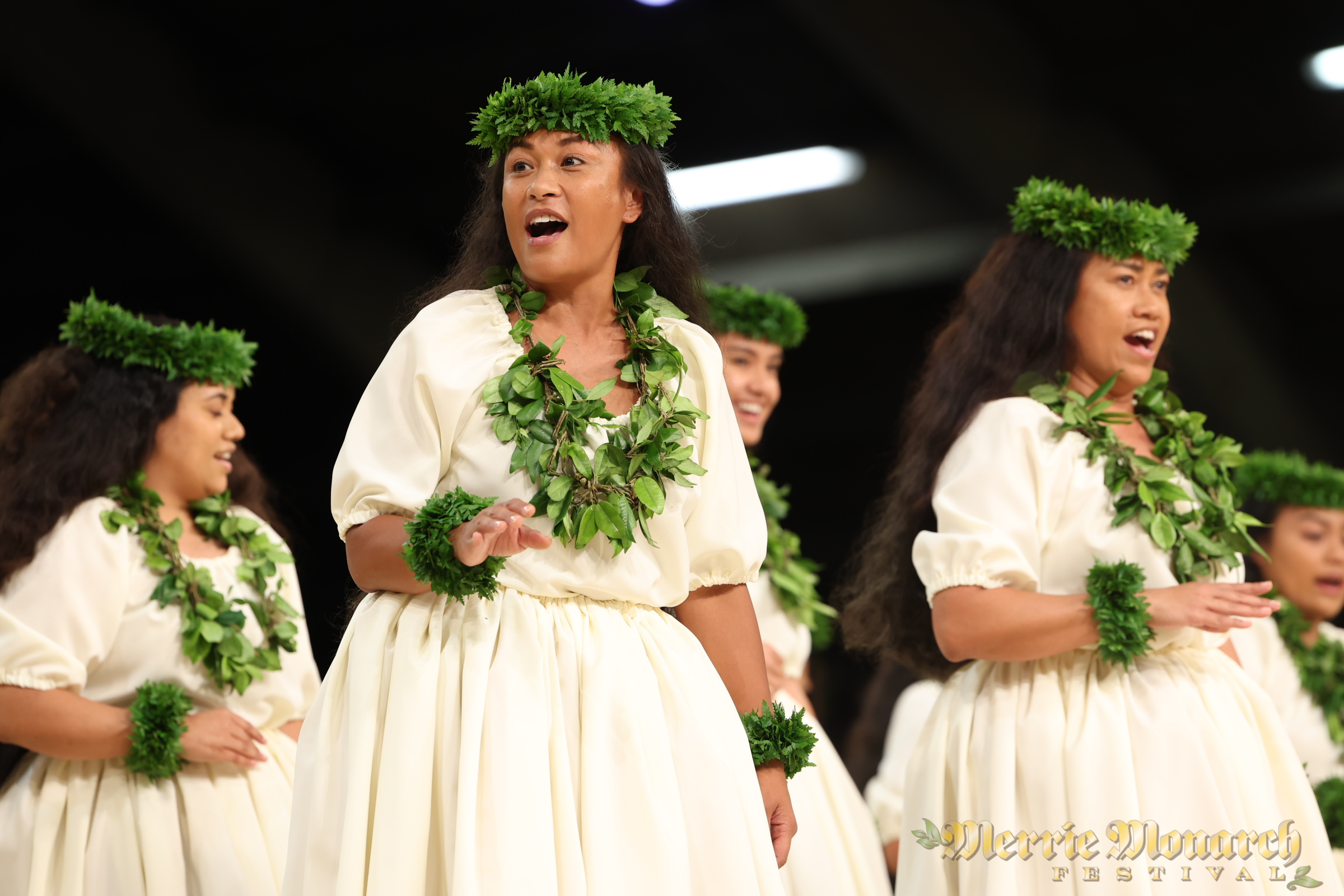 Wahine in white dress and twisted lei, chanting.